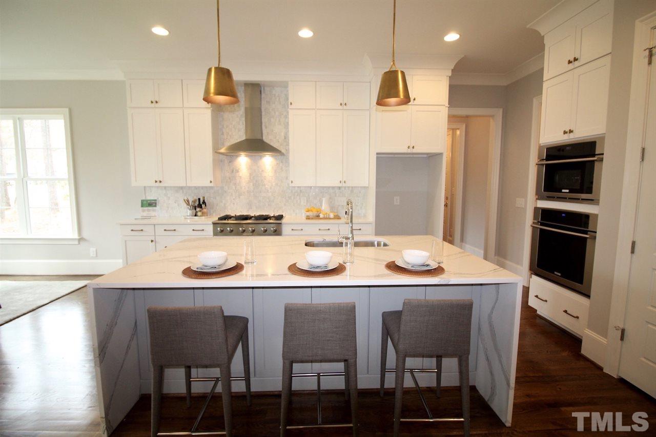 3013 Club Drive Raleigh, NC 27613 - Photo 10 of 25 a kitchen with stainless steel appliances kitchen island granite countertop a sink and cabinets