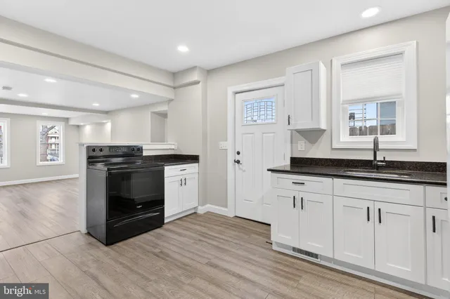 a kitchen with granite countertop a stove and cabinets