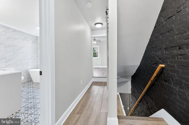 a view of a hallway with wooden floor and staircase