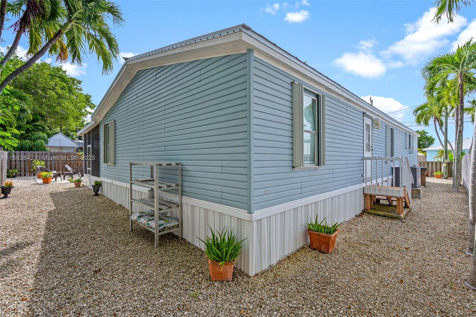 278 King Avenue Key Largo, FL 33037 - Photo 45 of 58 a backyard of a house with table and chairs under an umbrella