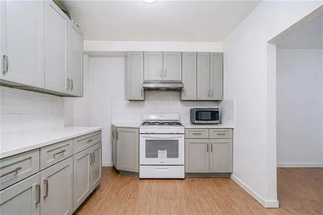a kitchen with white cabinets and white appliances