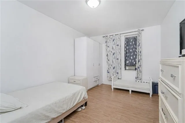 a bedroom with a bed and a refrigerator