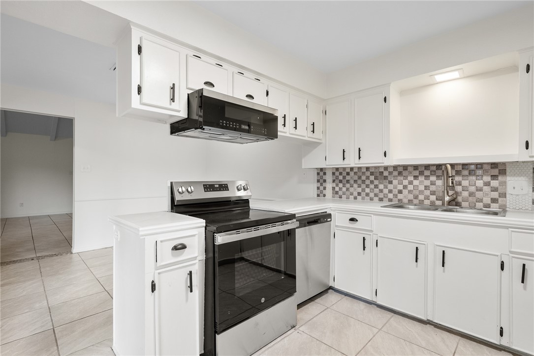 5009 Wingfoot Lane, Unit B Corpus Christi, TX 78413 - Photo 11 of 23 a kitchen with white cabinets stainless steel appliances and sink