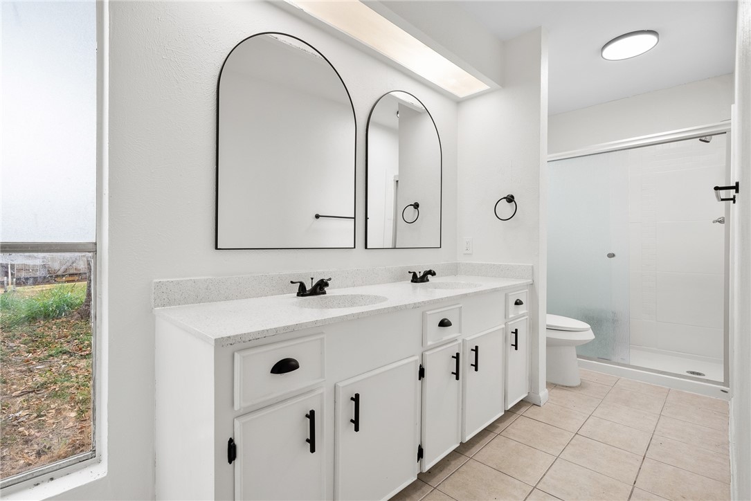 5009 Wingfoot Lane, Unit B Corpus Christi, TX 78413 - Photo 15 of 23 a bathroom with a double vanity sink mirror and toilet