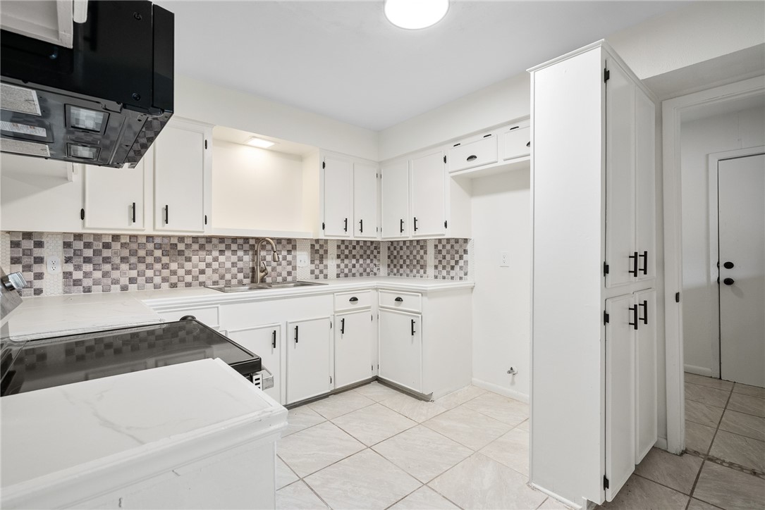 5009 Wingfoot Lane, Unit B Corpus Christi, TX 78413 - Photo 9 of 23 a kitchen with granite countertop white cabinets and white appliances