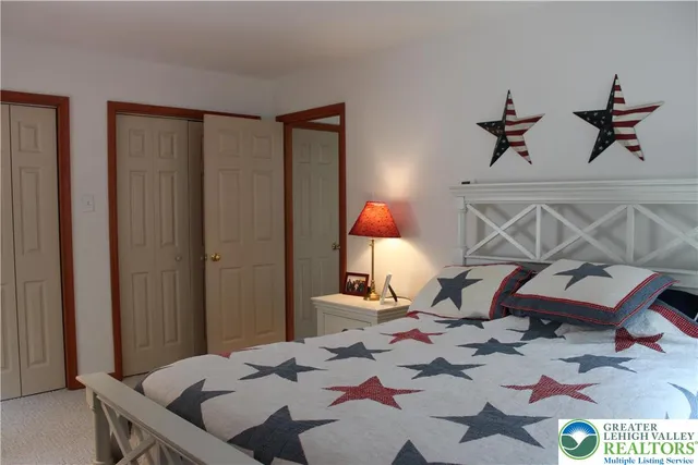 a bedroom with a bed a lamp and a closet