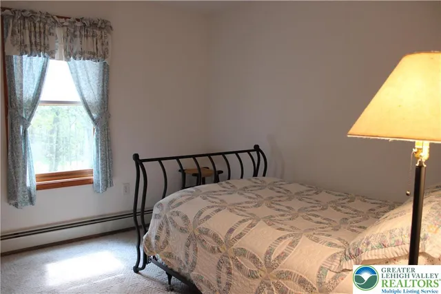 a large bed sitting in a bedroom next to a window