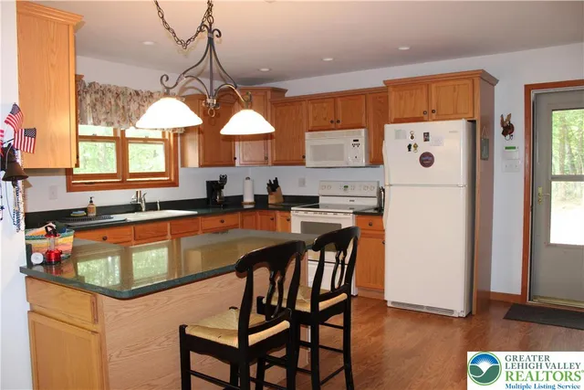 a kitchen with a table chairs refrigerator and window