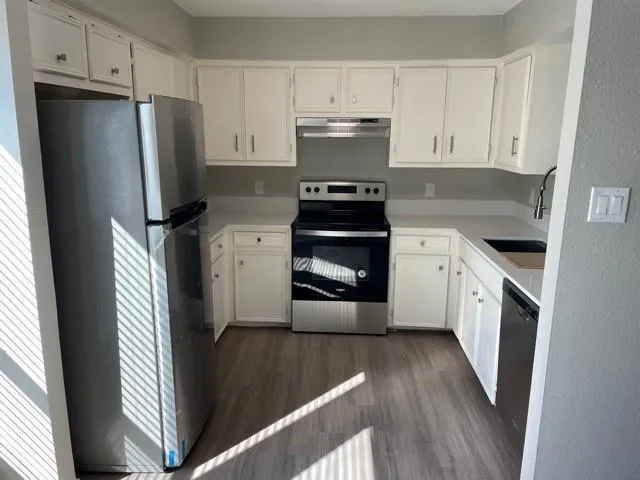 a kitchen with a refrigerator stove and wooden cabinets