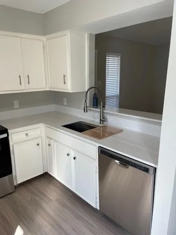 a kitchen with a sink cabinets and wooden floor