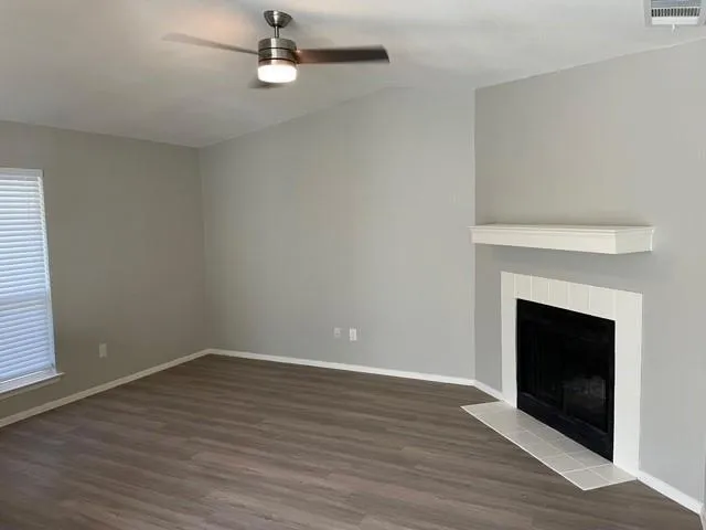 wooden floor fireplace and window in an empty room