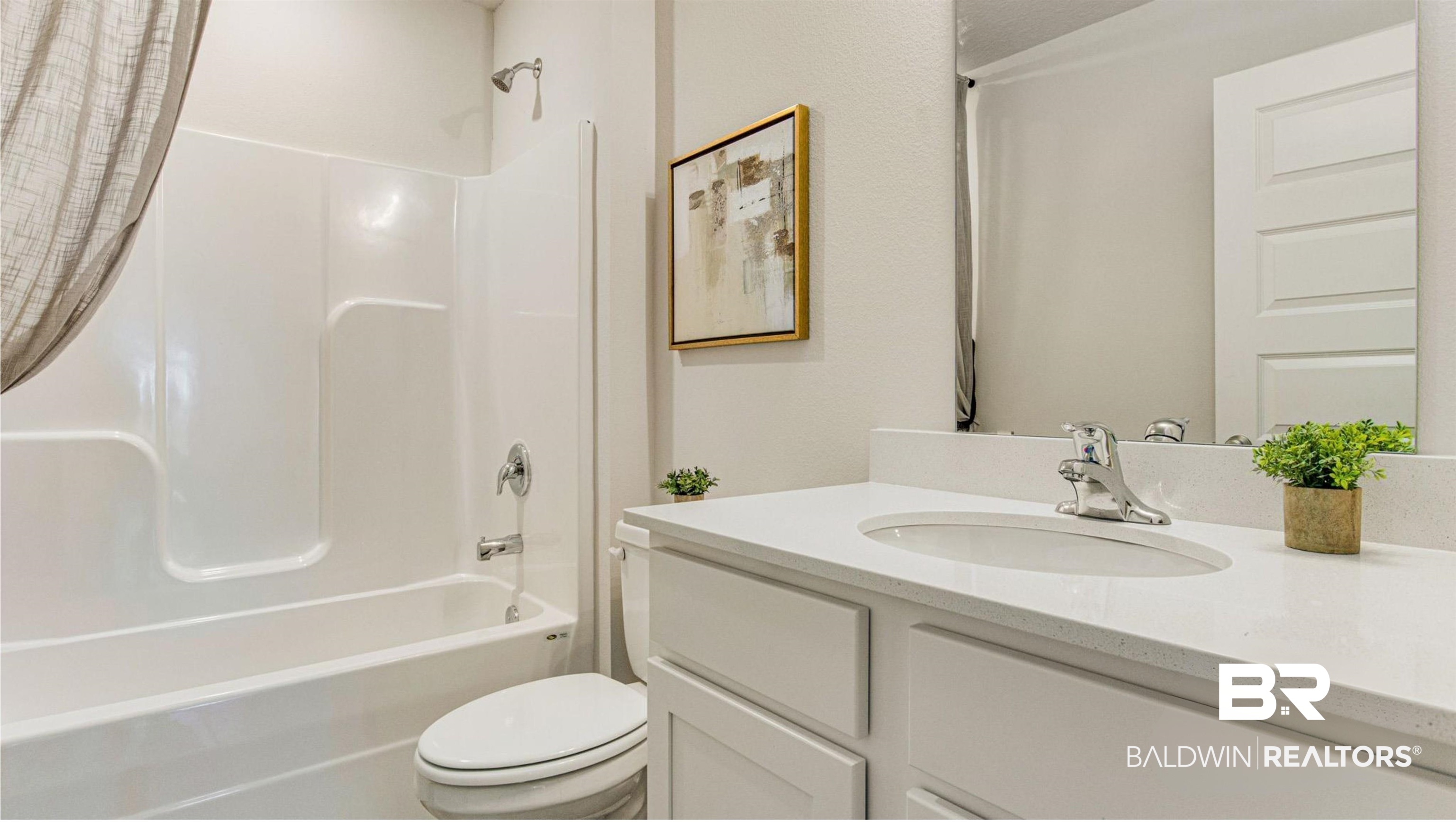 1040 Hayward Loop Foley, AL 36535 - Photo 4 of 35 Bathroom featuring a white integrated tub and shower unit, a vanity with a white countertop and integrated sink, a large wall-mounted mirror, and a contemporary panel door