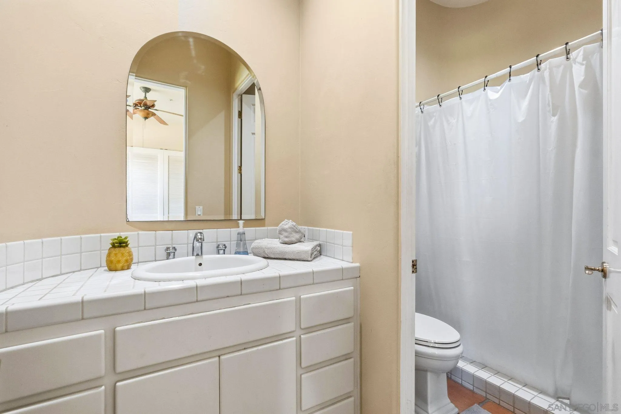 1035 Sleeping Indian Road Oceanside, CA 92057 - Photo 11 of 22 a bathroom with a granite countertop sink a toilet and a mirror