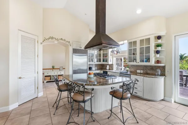 a kitchen with stainless steel appliances a table and chairs in it