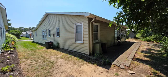 a view of a house with backyard and trees