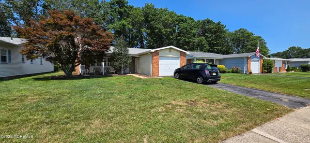 a front view of a house with a garden and trees