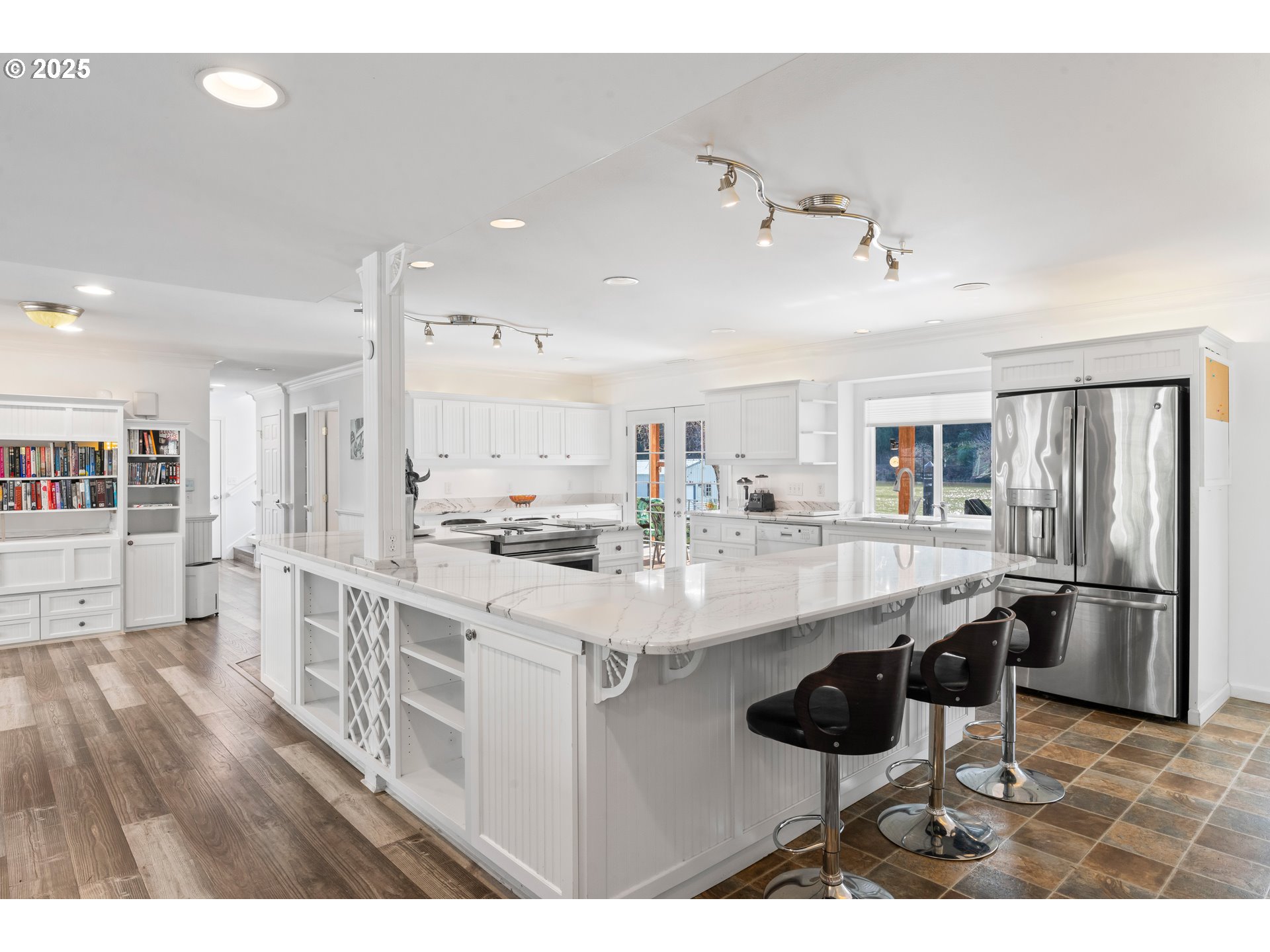 9202 Phey Lane Florence, OR 97439 - Photo 16 of 47 a kitchen with stainless steel appliances kitchen island granite countertop a table chairs and a refrigerator