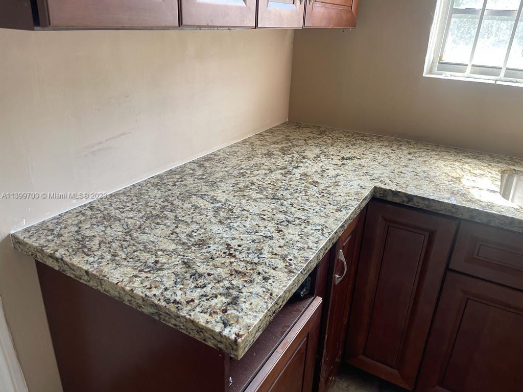 121 Northwest 53rd Street Miami, FL 33127 - Photo 5 of 5 a kitchen with a granite countertop sink and dishwasher