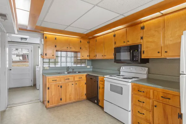 a kitchen with stainless steel appliances granite countertop a stove a sink and a microwave