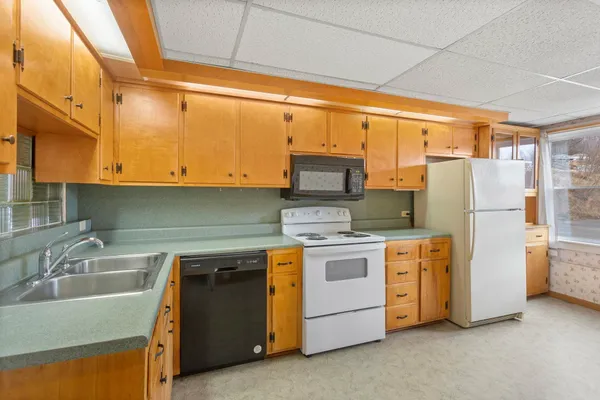 a kitchen with appliances a sink and cabinets