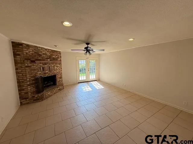 an empty room with windows and fireplace