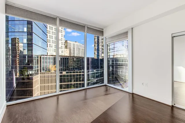 a view of a hallway with wooden floor and cabinet