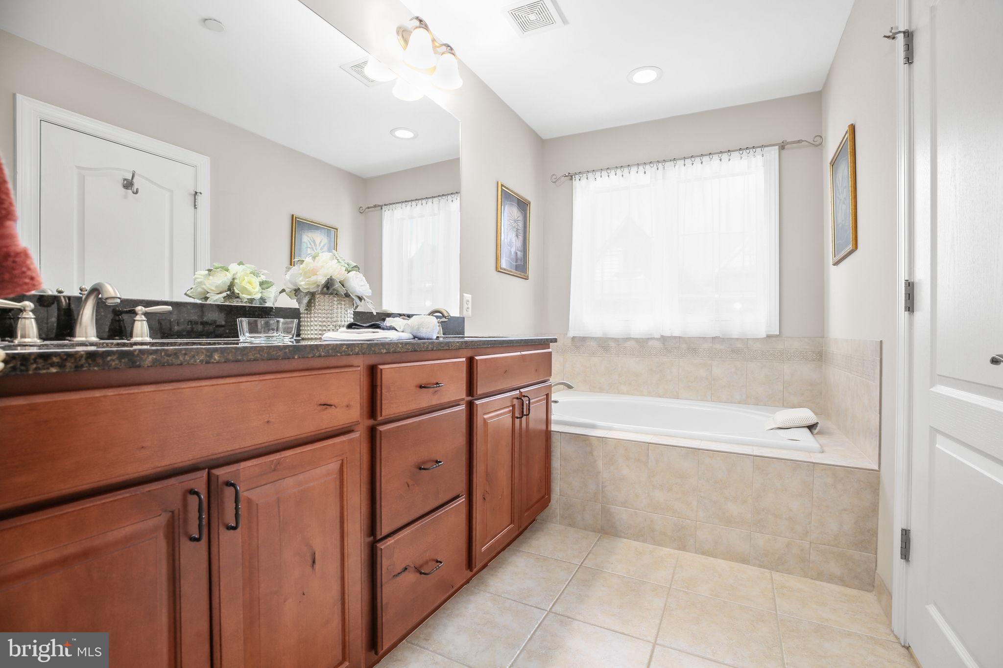 229 Mill Street Occoquan, VA 22125 - Photo 23 of 61 a bathroom with a double vanity sink a mirror and a bathtub