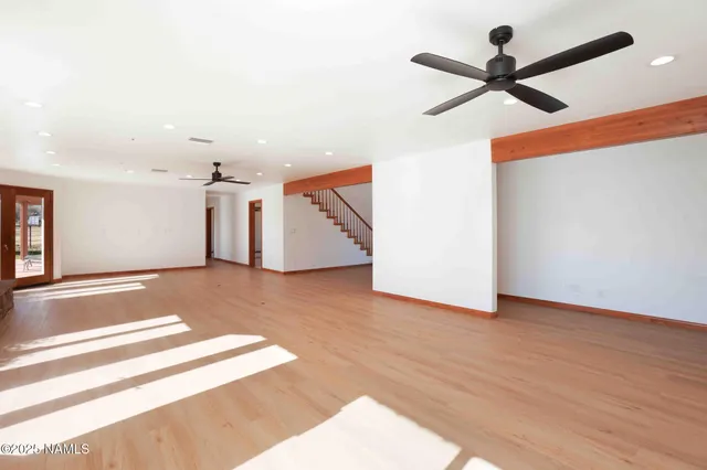 a large white kitchen with granite countertop a stove top oven a sink a dishwasher and white cabinets