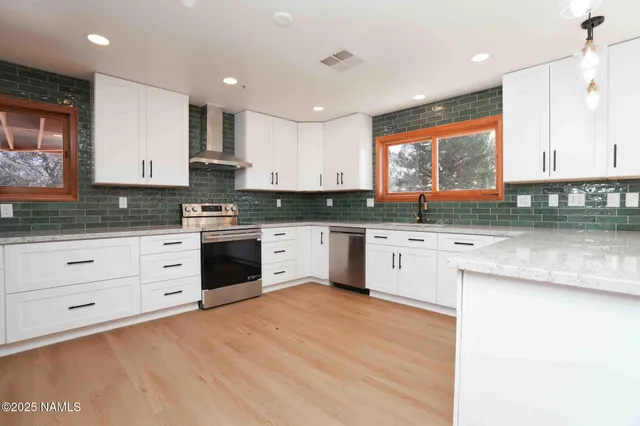 a view of a kitchen with wooden floor and a window