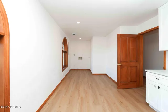 a view of a hallway with wooden floor and windows