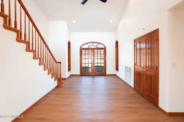 a view of an empty room with a window and a ceiling fan