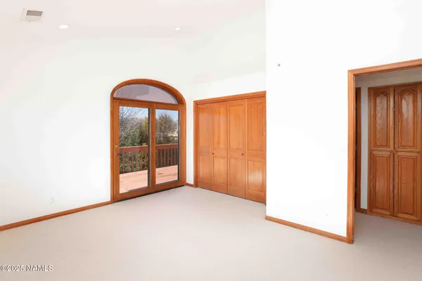 a view of an empty room with a window and closet