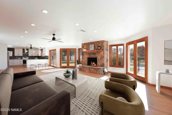 a view of a livingroom with wooden floor and a ceiling fan