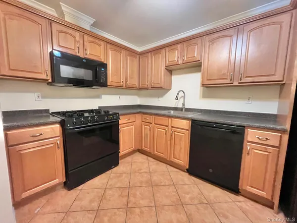 a kitchen with granite countertop cabinets stainless steel appliances and a sink