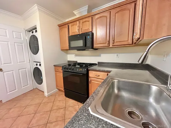a kitchen with granite countertop a sink a stove a microwave and cabinets