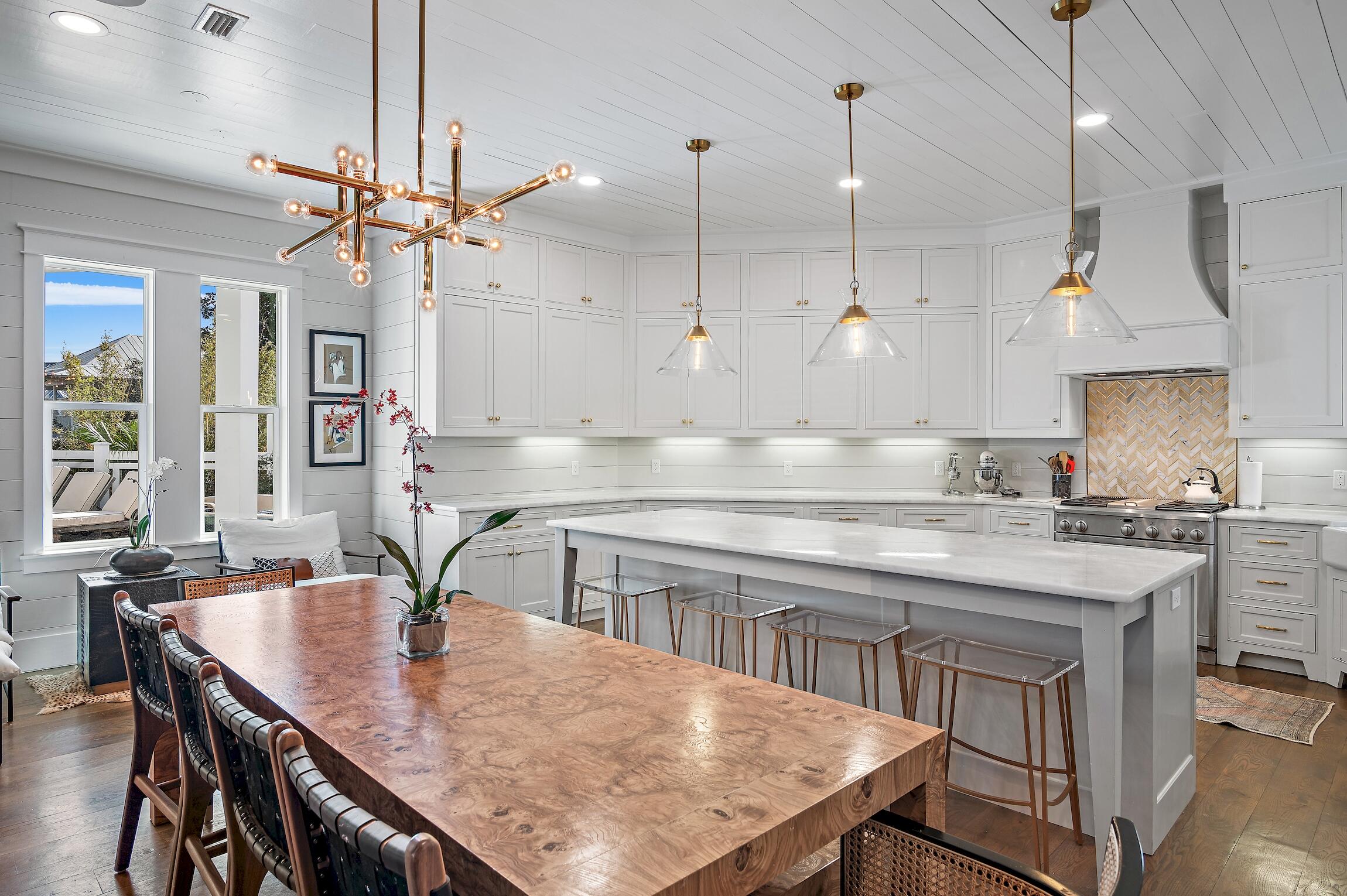 87 Bullard Road Santa Rosa Beach, FL 32459 - Photo 10 of 37 a kitchen with stainless steel appliances granite countertop a kitchen island a stove a sink a dining table and chairs