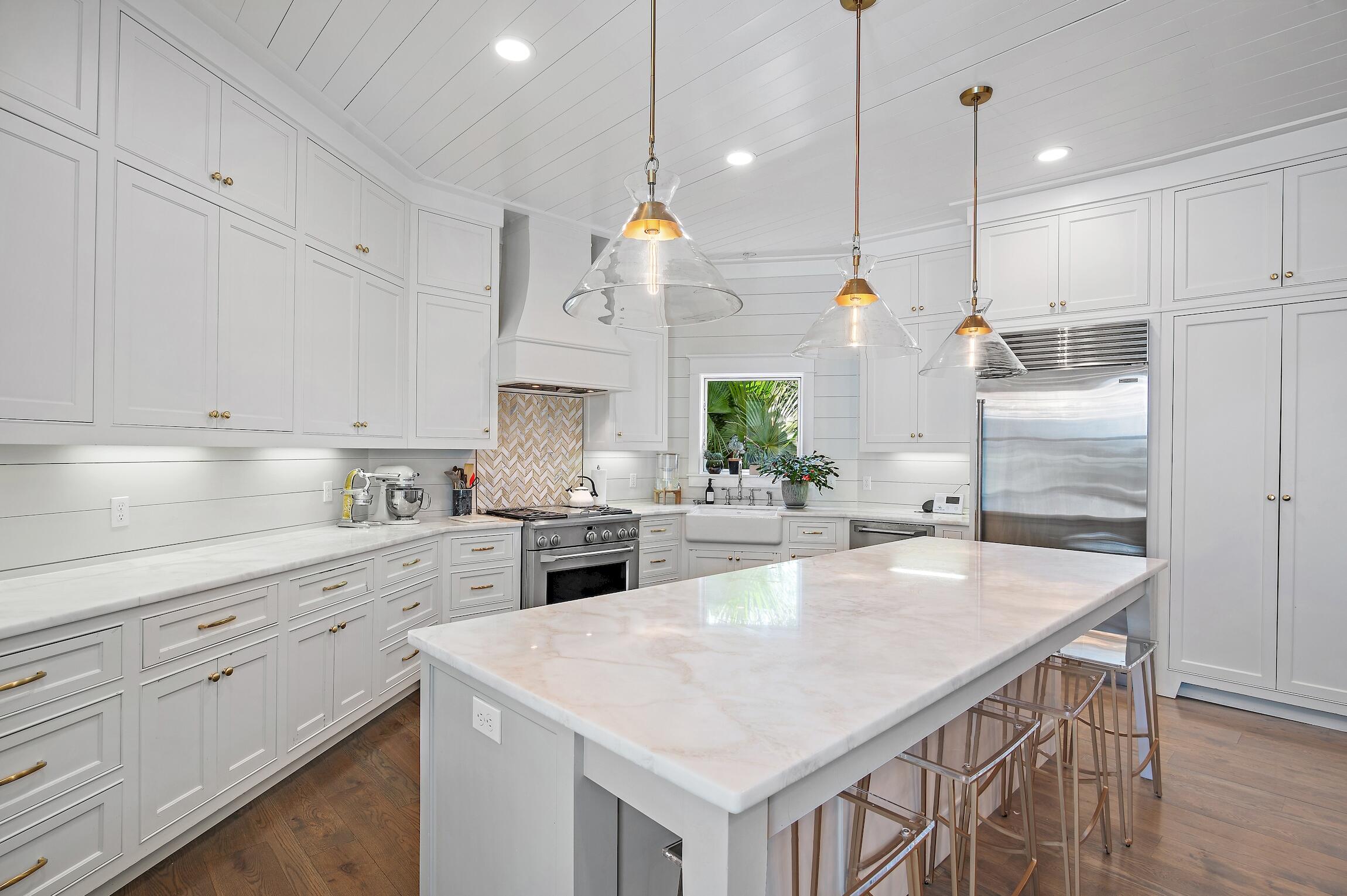 87 Bullard Road Santa Rosa Beach, FL 32459 - Photo 12 of 37 a kitchen with white cabinets and stainless steel appliances