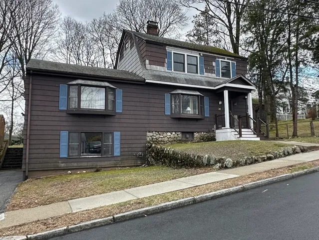 a front view of a house with a yard garage and glass windows