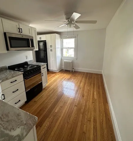 a kitchen with granite countertop a stove a sink and a microwave