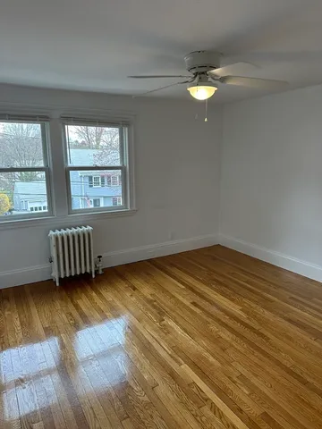 a view of a room with wooden floor and window