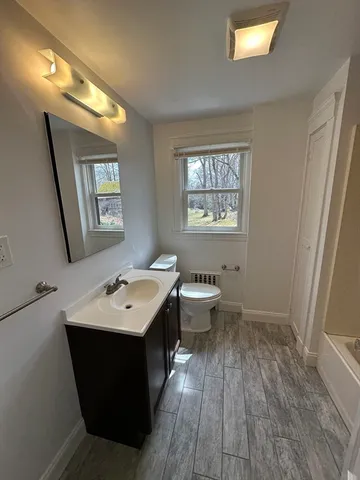 a bathroom with a toilet sink and mirror