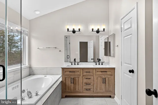 a bathroom with a tub sink and mirror