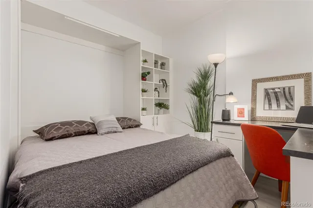 a bedroom with a bed a table and chair