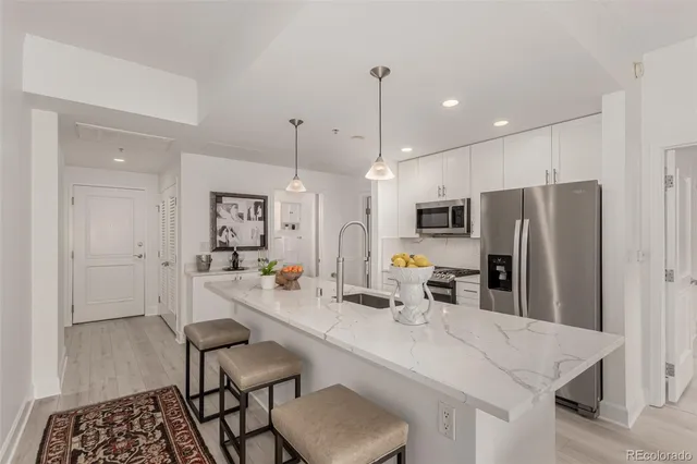 a kitchen with stainless steel appliances a refrigerator sink and stove