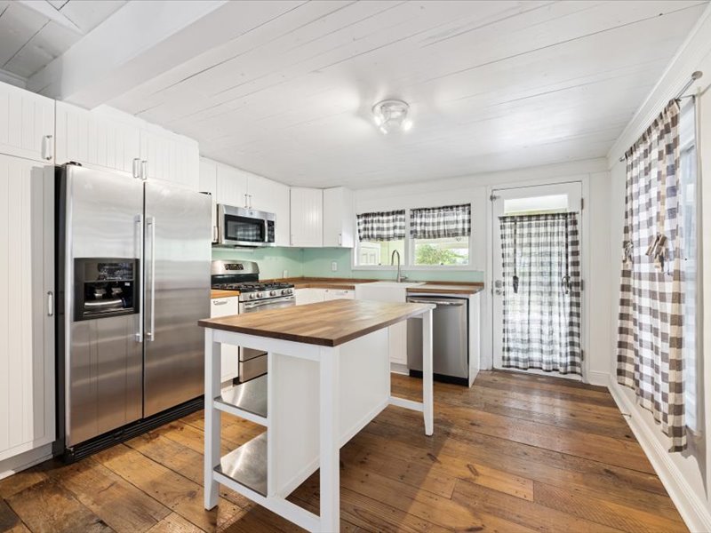 a kitchen with granite countertop a refrigerator stove and sink