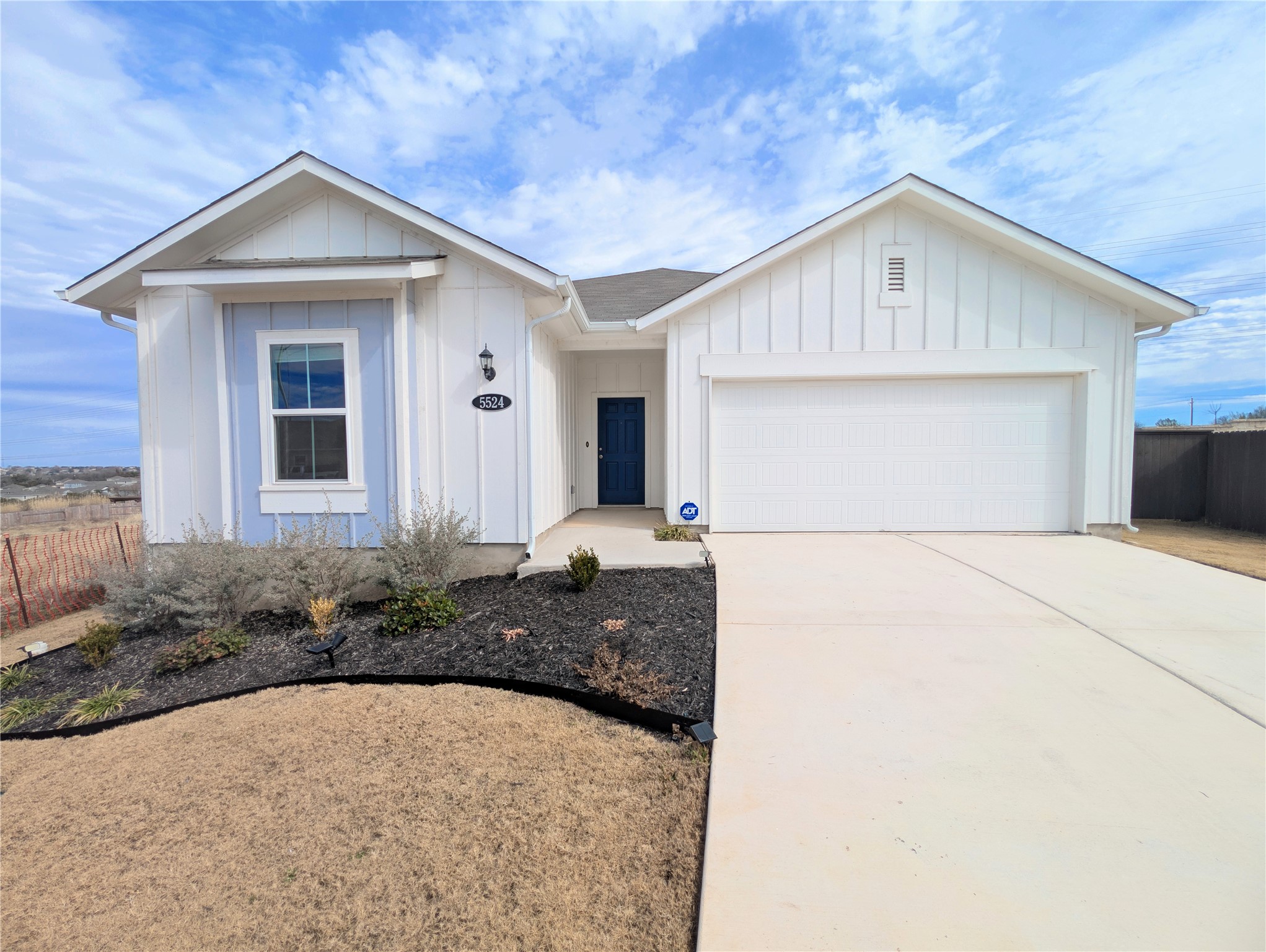5524 Sacra Cove Austin, TX 78747 - Photo 1 of 37 View of front of property featuring board and batten siding, a garage, and driveway