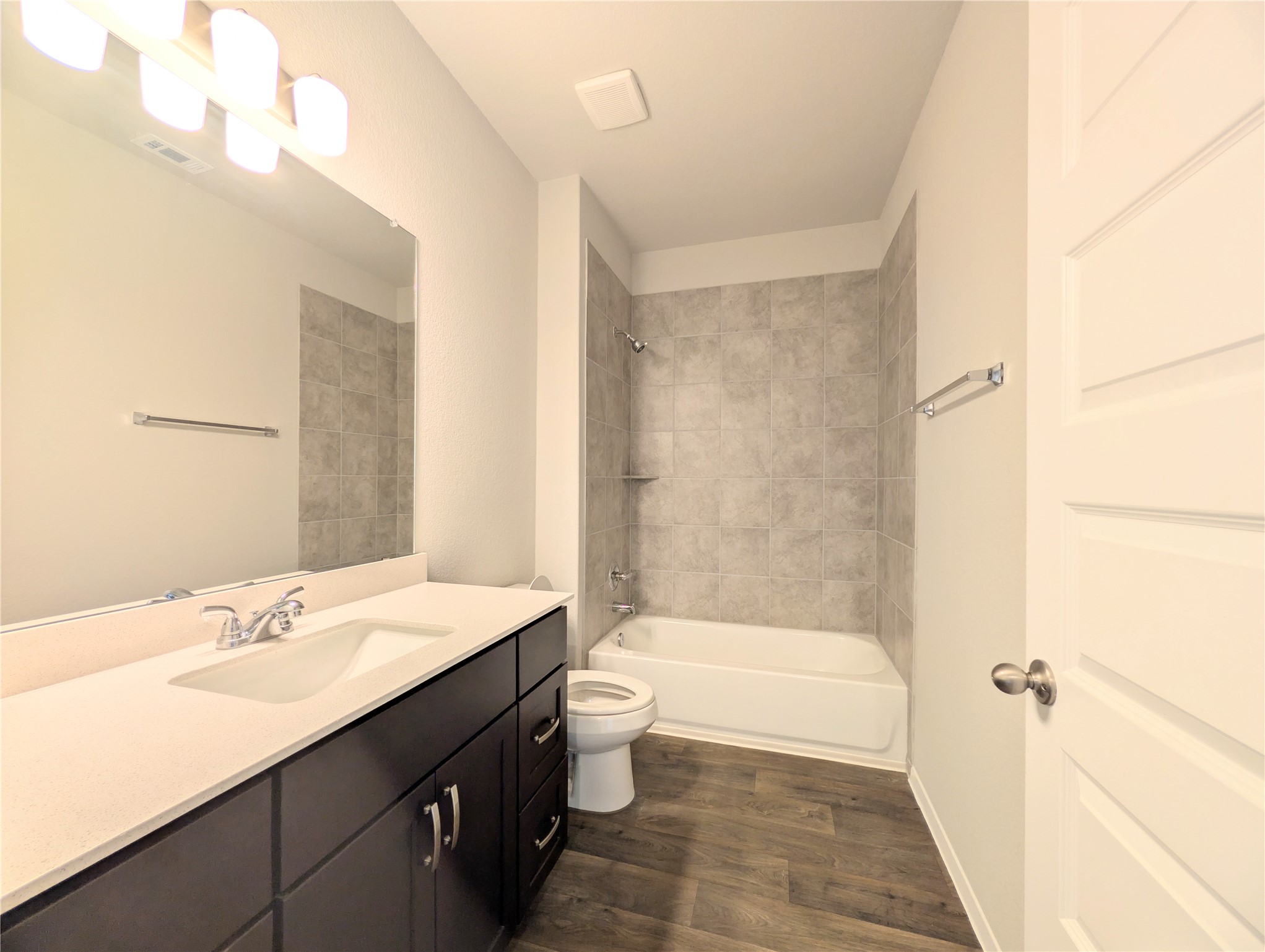 5524 Sacra Cove Austin, TX 78747 - Photo 14 of 37 Guest bathroom with vanity, dark wood-style floors, and bathing tub / shower combination