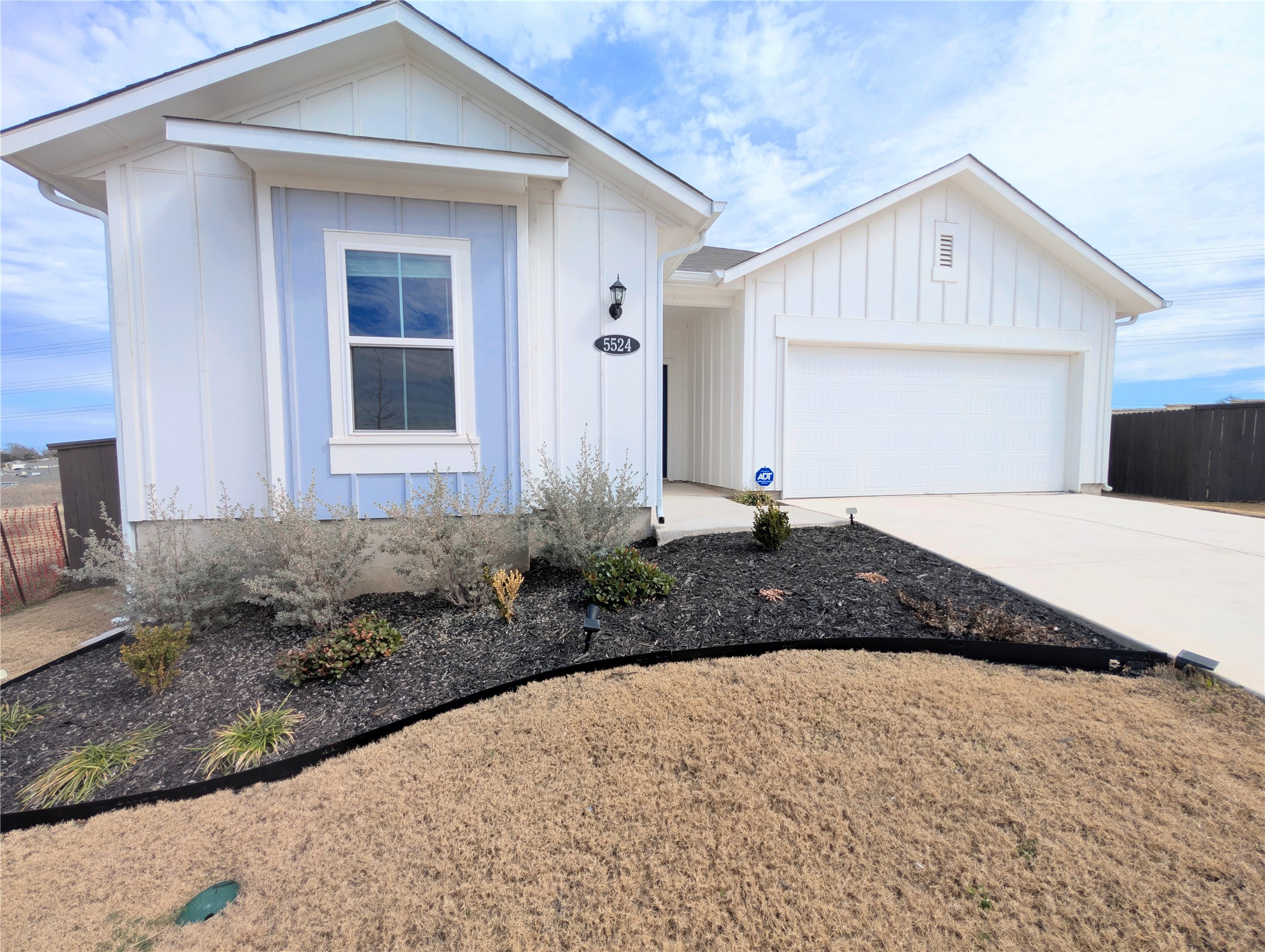 5524 Sacra Cove Austin, TX 78747 - Photo 2 of 37 View of front of property featuring a garage, board and batten siding, and driveway