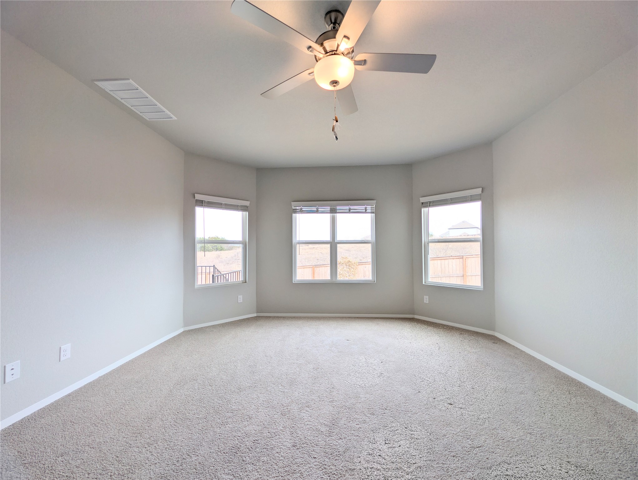 5524 Sacra Cove Austin, TX 78747 - Photo 21 of 37 Primary bedroom with ceiling fan, carpet flooring, and plenty of natural light