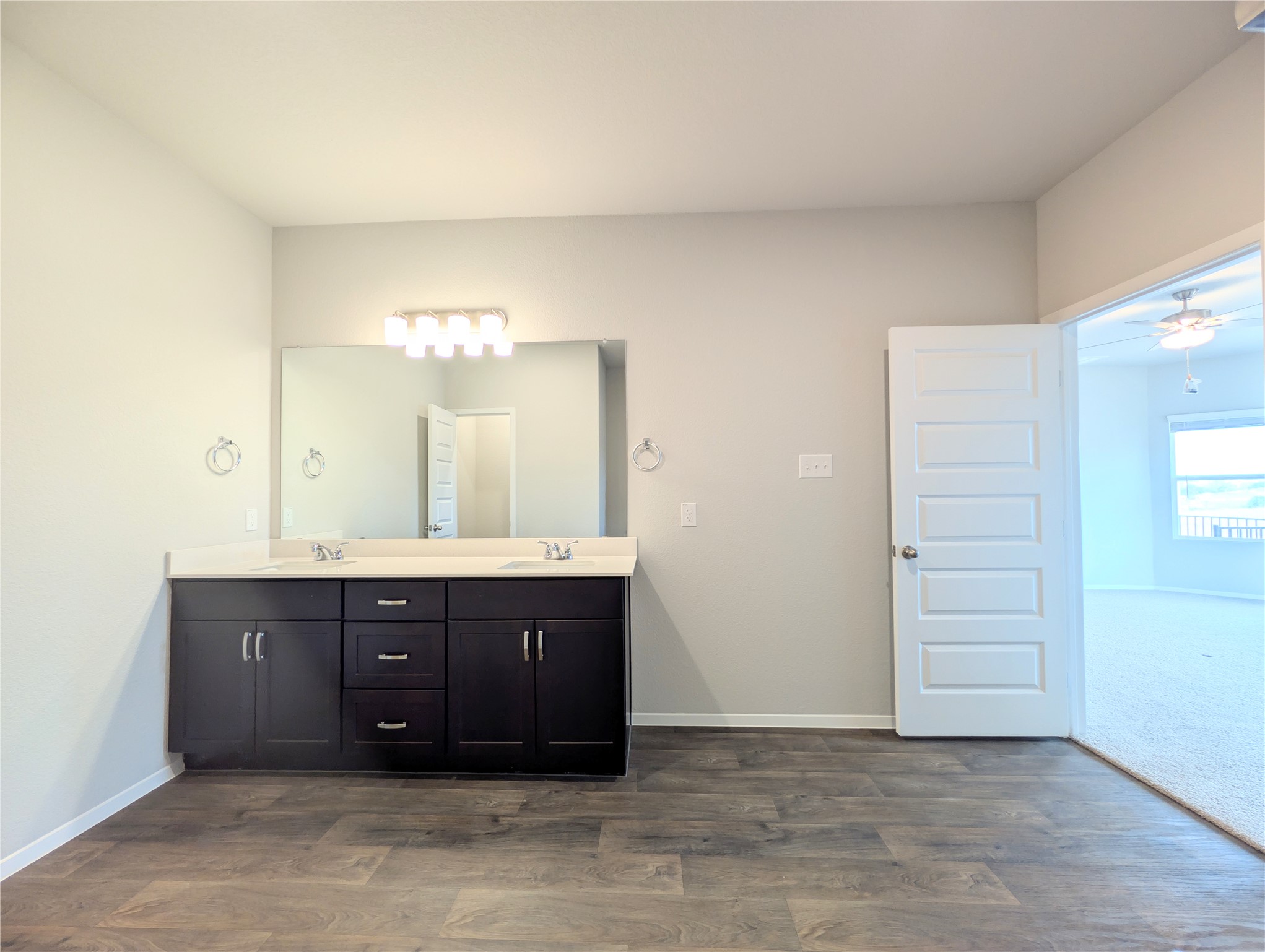 5524 Sacra Cove Austin, TX 78747 - Photo 23 of 37 Bathroom featuring double vanity, dark wood-type flooring, and ceiling fan